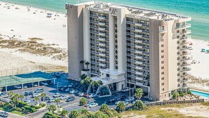 A high-rise hotel with multiple balconies, a swimming pool, and a beach view. - Wonderful Condo in Beachfront Complex w/Shared Pool & Hot Tub, Free WiFi, AC (Orange Beach)