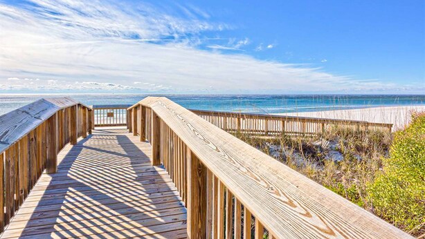 A wooden boardwalk leading to a beach with a clear sky. - Excellent resort suite in beachfront location with WiFi, pool & elevator (Orange Beach)