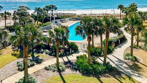 A pool surrounded by palm trees, a beach view, and a clear sky. - Excellent resort suite in beachfront location with WiFi, pool & elevator (Orange Beach)