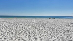 A wide sandy beach with a clear blue sky and calm sea. - Beachfront Suite with Free WiFi, Elevator, Shared Pool, and Central AC (Orange Beach)