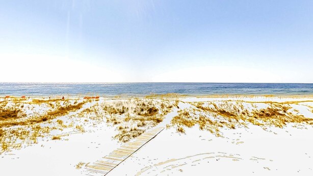 A beach with a wooden boardwalk leading to the water. - Gulf-front home on the beach with 3-tier deck, Gulf views & pool access (Orange Beach)