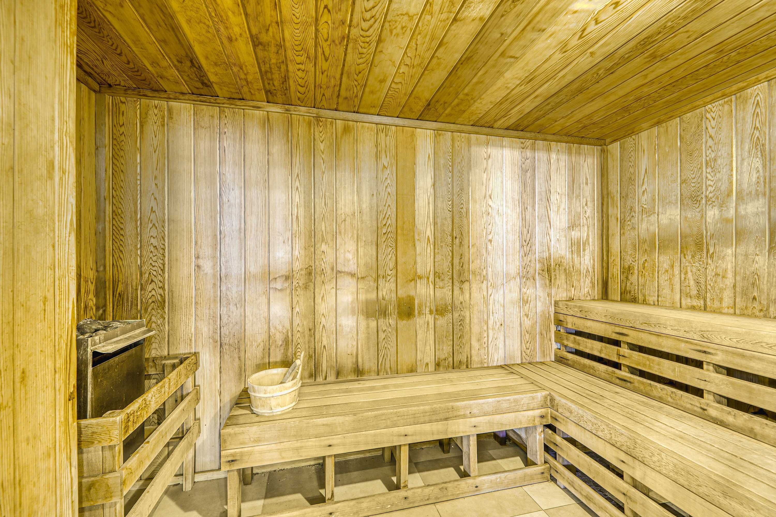A wooden sauna with benches and a bucket.