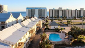 A hotel with multiple-story buildings, a swimming pool, and a view of the ocean. - Coastal escape with 2 water-view balconies, 2 pools, tennis & beach access (Orange Beach)