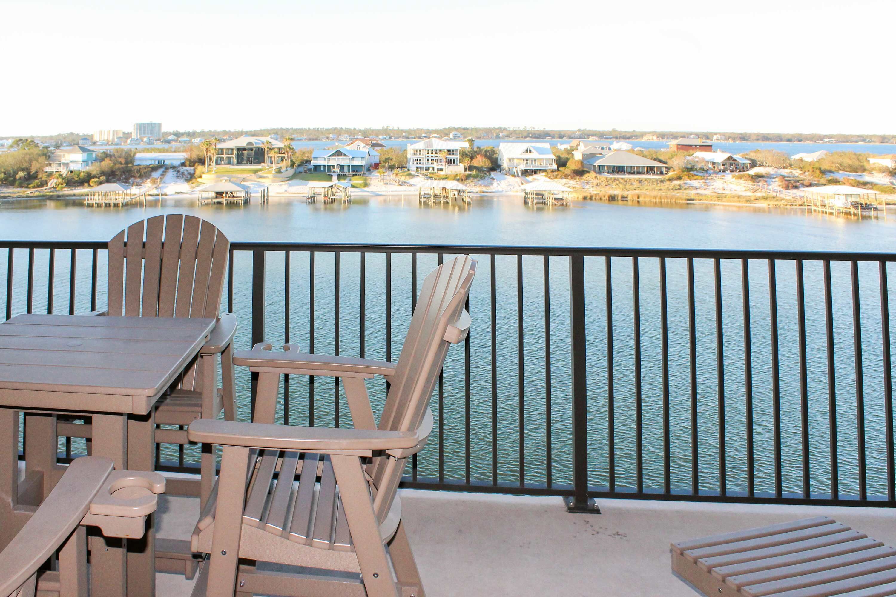 Un balcon donnant sur un lac, avec des maisons en arrière-plan.