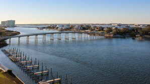 A river with a bridge and docks. - Coastal escape with 2 water-view balconies, 2 pools, tennis & beach access (Orange Beach)