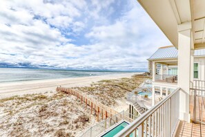 A beachfront property with a pool, a beach view, and a staircase leading to a balcony. - Luxurious Gulf-front home w private plunge pool, steps from the beach (Orange Beach)