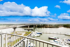 A marina with boats docked, a bridge in the background, and a clear sky. - Seventh-Floor Condo with Free WiFi, Bay Views, Shared Outdoor Pool, Hot Tub, Gym (Orange Beach)