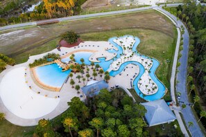 An aerial view of a resort with multiple swimming pools, palm trees, and a road. - Seventh-Floor Condo with Free WiFi, Bay Views, Shared Outdoor Pool, Hot Tub, Gym (Orange Beach)