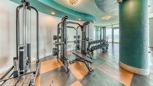Ein Fitnessstudio mit Gewichthebern, einer Bank und Kurzhanteln.