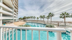 Ein Hotel mit Pool, Palmen und Blick auf den Strand.