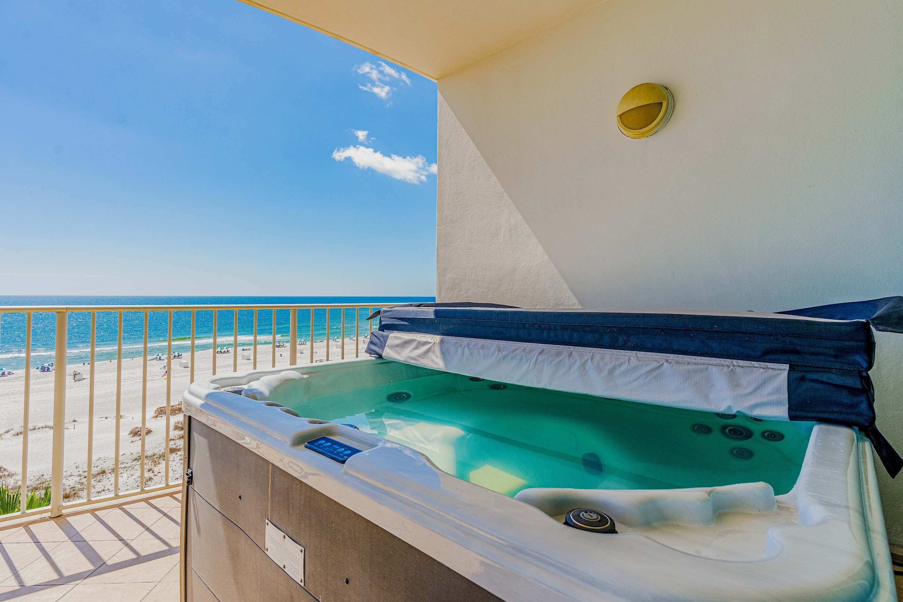 Ein Whirlpool auf einem Balkon mit Blick auf Strand und Meer.