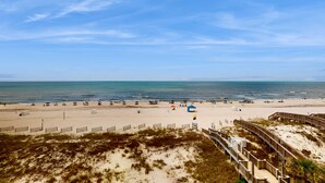 A beach with a wooden boardwalk, sandy beach, and ocean view. - Beachfront condo w/ private, corner balcony, community pools, & a grilling area (Orange Beach)