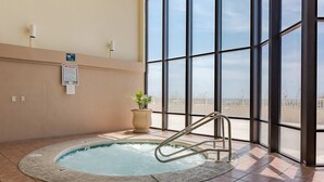A hot tub with a metal ladder, a potted plant, and a sign on the wall. - Beachfront condo w/ private, corner balcony, community pools, & a grilling area (Orange Beach)