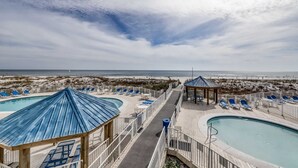 A resort with multiple swimming pools, lounge areas, and a beach view.