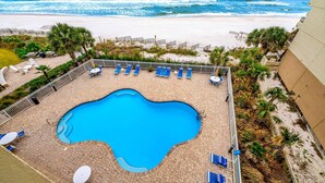 A swimming pool with lounge chairs and a view of the beach. - Beachfront condo with Gulf front shared pool, private balcony, and grilling area (Orange Beach)