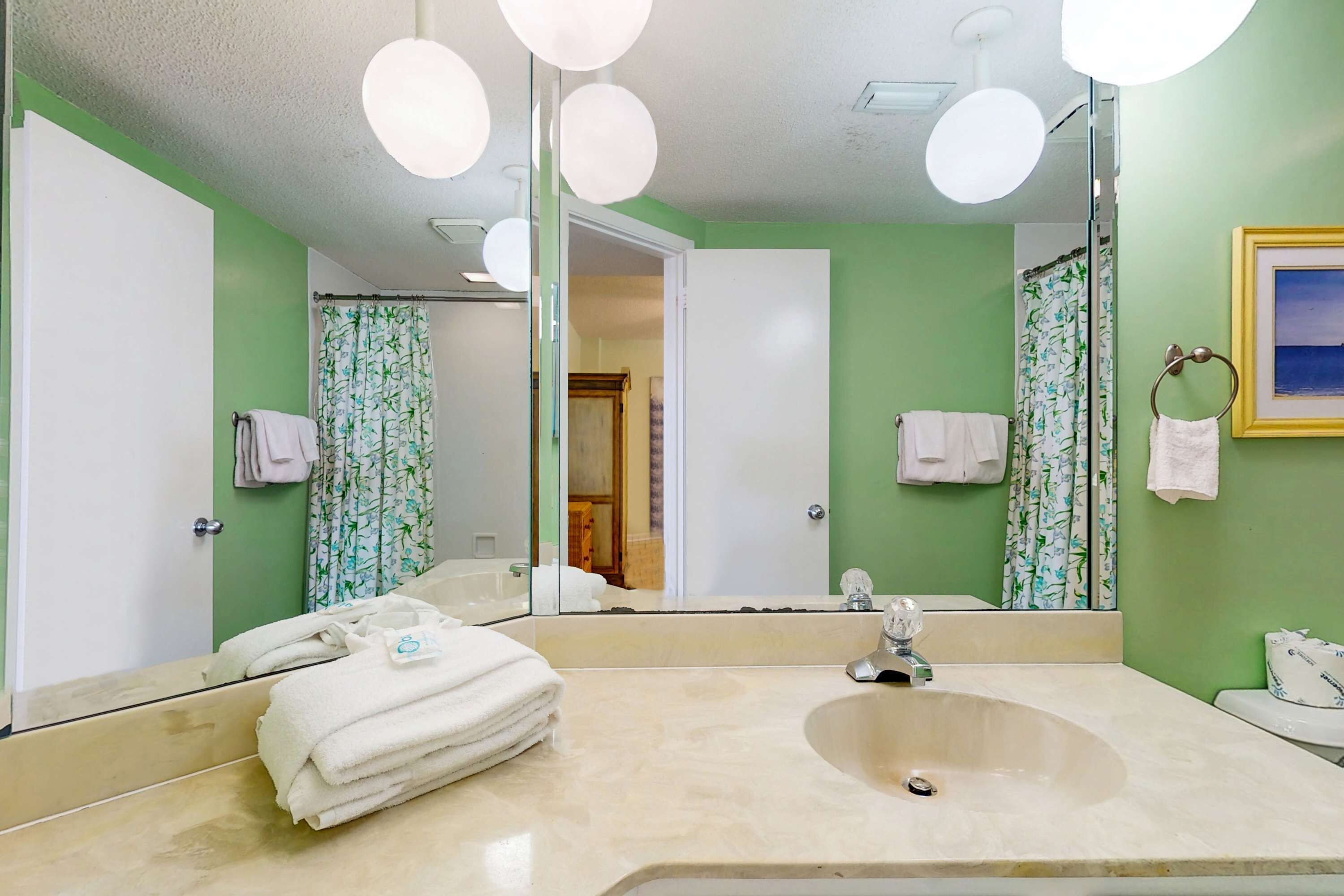 Une salle de bain équipée d’un lavabo, d’un miroir et d’un porte-serviettes.