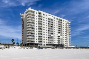 A multi-story hotel with balconies, located near a beach. - Updated, Gulf front condo with beautiful views, shared pool, sauna, and hot tub (Orange Beach)