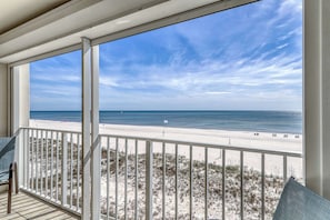 A balcony with a view of a beach and ocean. - Updated, Gulf front condo with beautiful views, shared pool, sauna, and hot tub (Orange Beach)