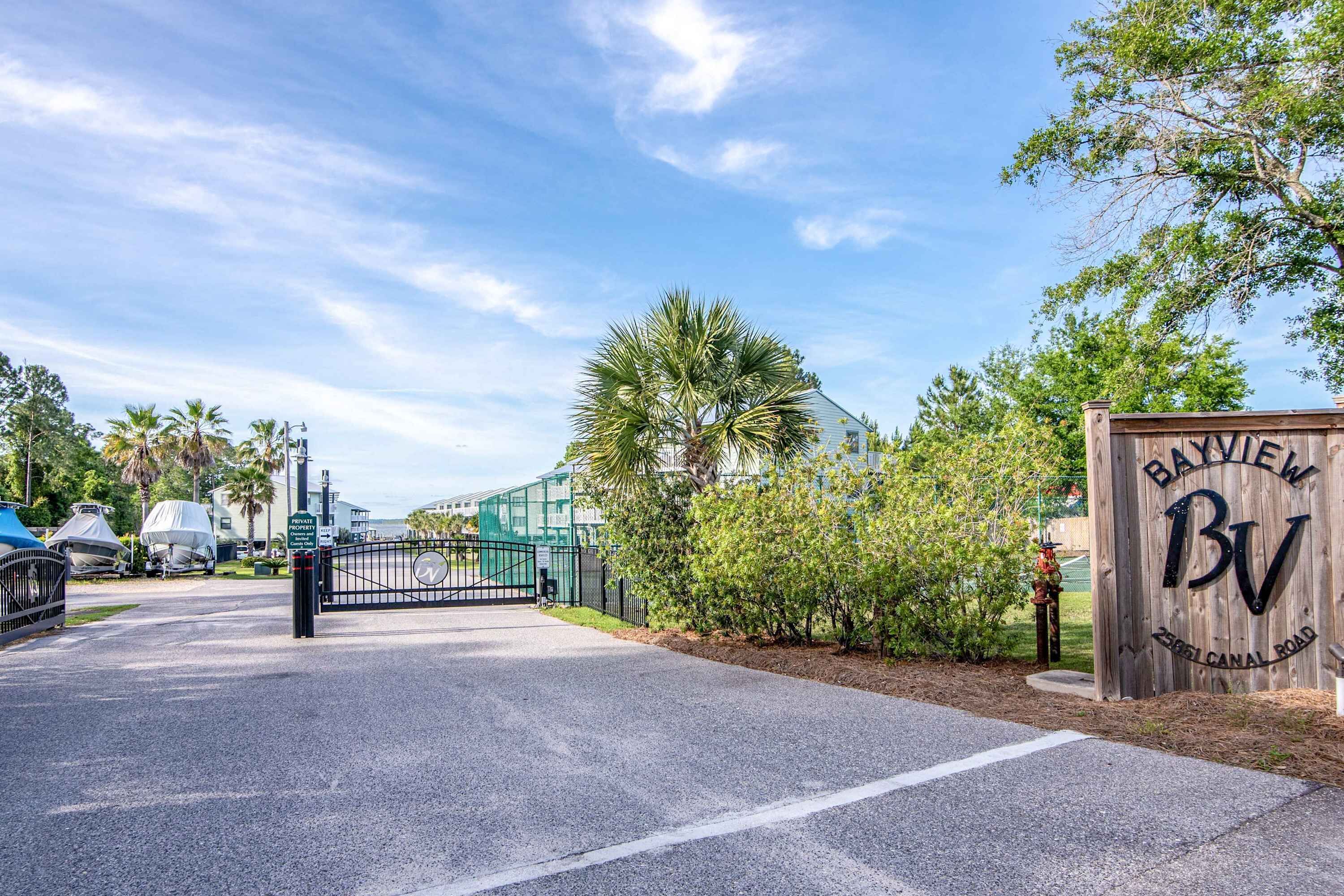 A gated entrance with a wooden sign reading 'Bayview' and '2501 Canal Road.'
