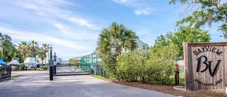 A gated entrance with a wooden sign reading 'Bayview' and '2501 Canal Road.'