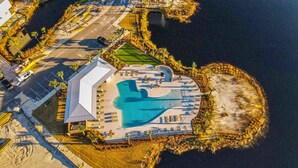 Een luchtbeeld van een resort met een groot zwembad, een overdekt gedeelte en een strand.