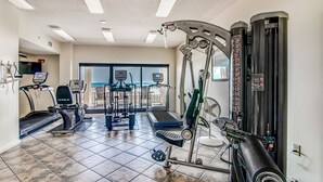 Ein Fitnessstudio mit Laufbändern, Crosstrainern und Gewichten.