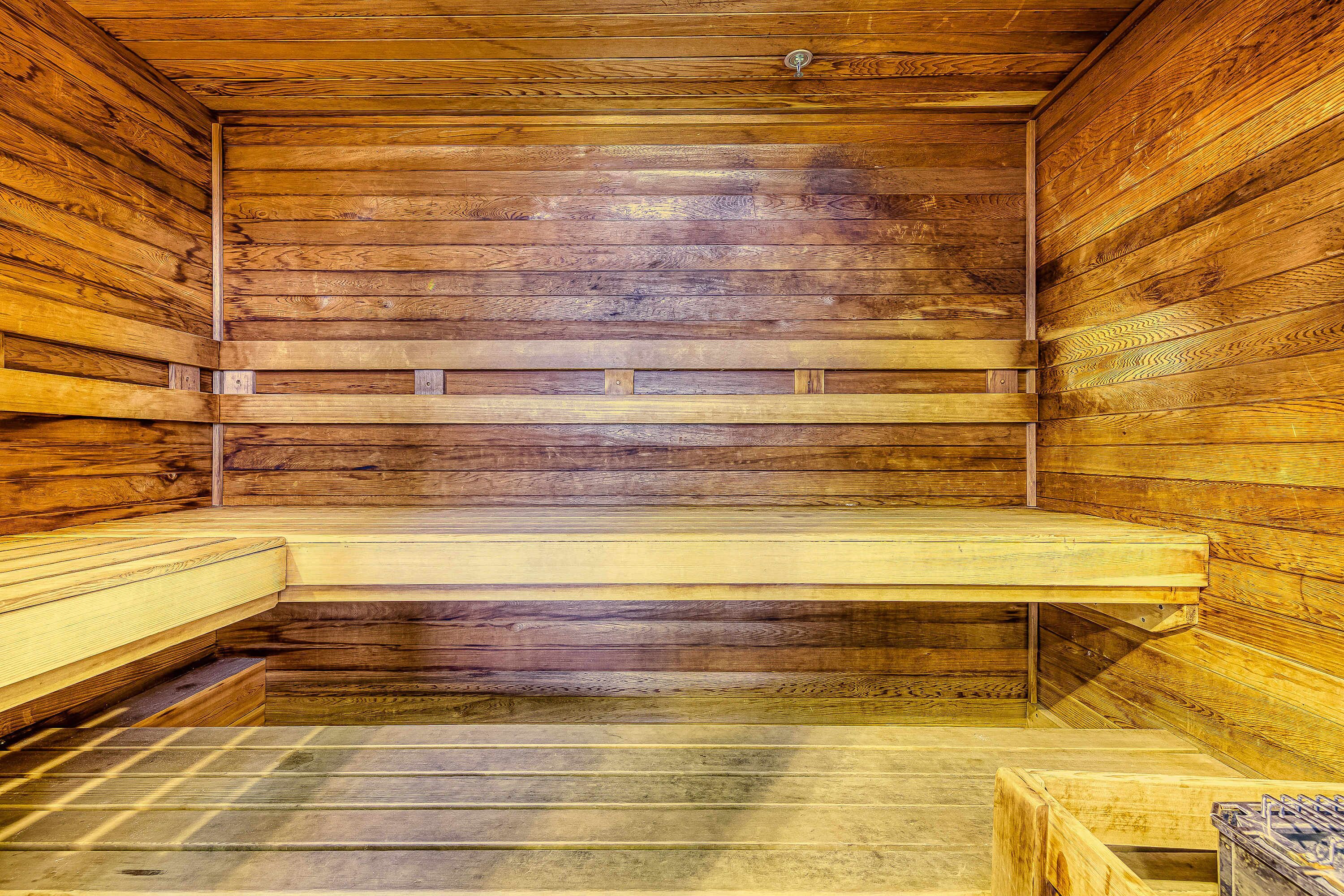Un sauna avec des murs et des bancs en bois.
