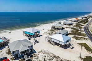 A coastal property with multiple buildings, a beach, and a road. - Gulf-Front Oasis: Rooftop Heated Pool, Elevator & Dog-Friendly! (Dauphin Island)