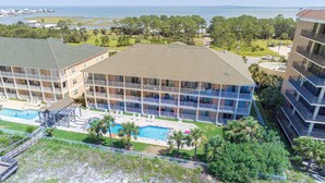 Un hôtel à plusieurs étages doté d’une piscine, de balcons et offrant une vue sur l’océan et le pont.