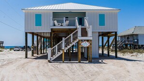 A beach house with a balcony, wooden stairs, and a sign indicating a beach view. - 2 dog-friendly beach houses right on the sand w/private heated pool & elevator (Dauphin Island)