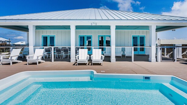 A pool area with lounge chairs and a covered seating area. - 2 dog-friendly beach houses right on the sand w/private heated pool & elevator (Dauphin Island)