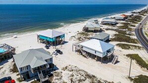 A coastal property with multiple buildings, a beach, and a road. - 2 dog-friendly beach houses right on the sand w/private heated pool & elevator (Dauphin Island)