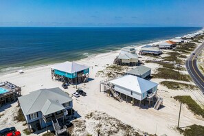 A coastal property with multiple buildings, a beach, and a road. - 2 dog-friendly beach houses right on the sand w/private heated pool & elevator (Dauphin Island)