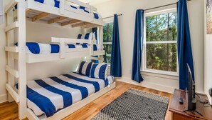 A bunk bed room with a window, a flat-screen TV, and a rug. - Peaceful hideaway with modern interior & spacious balcony - adjacent to the dune (Dauphin Island)
