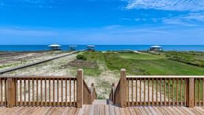 A wooden deck leading to beach huts with a clear view of the ocean. - Idyllic, dog-friendly Bay Front Island home with pool, Gulf view & large decks (Dauphin Island)