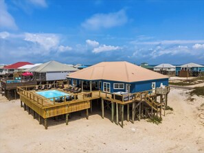 A beachfront property with a pool, wooden deck, and multiple buildings with elevated structures. - Coastal Gem on the Sand With Large Deck, Ocean Views & Private Pool & Hot Tub (Dauphin Island)