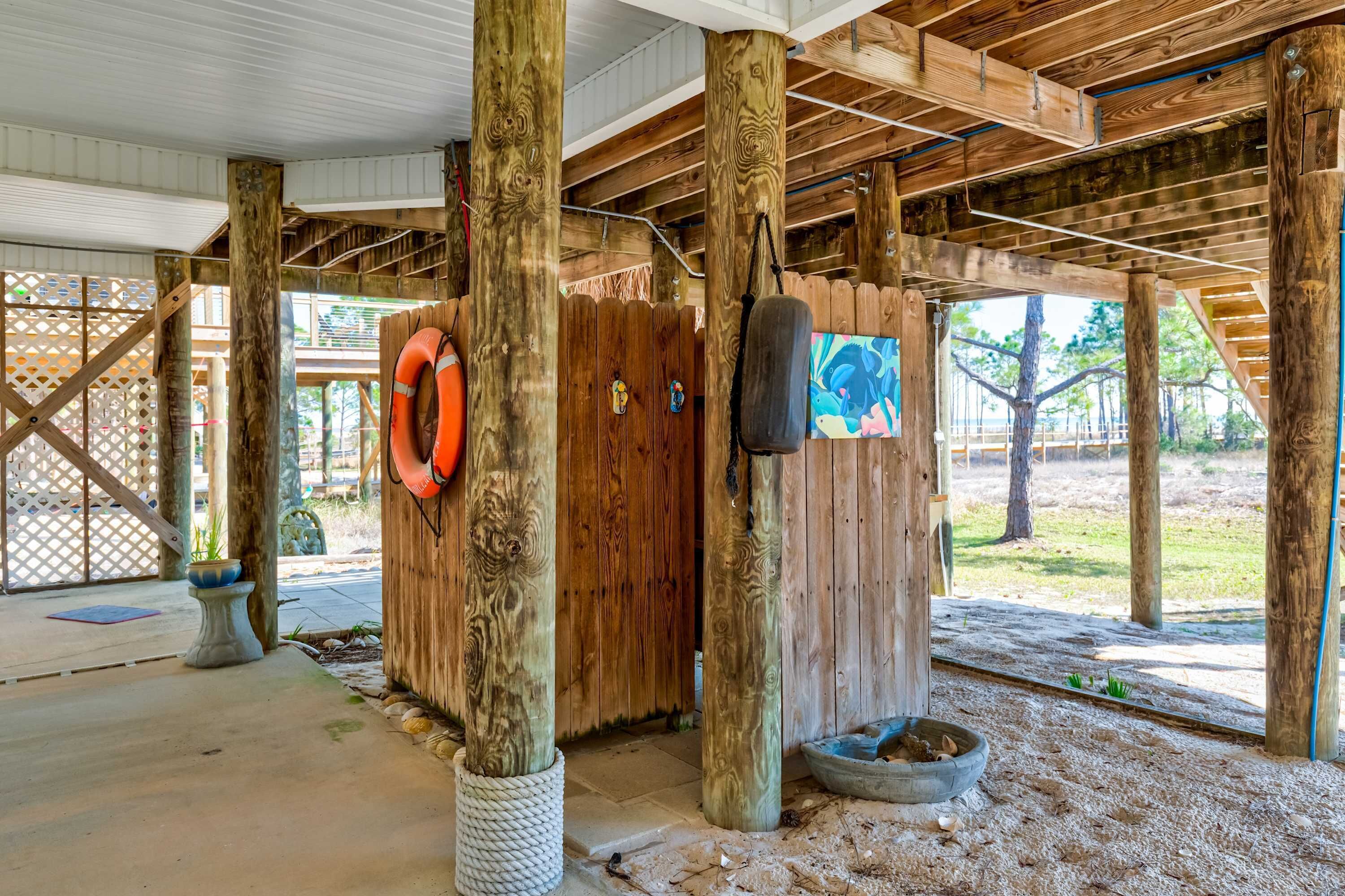 A wooden structure with a rope-wrapped column, a lifebuoy, and a punching bag.