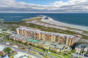 A large hotel with multiple floors, a parking lot, and a beach view. - Lovely Gulf front condo w/shared sauna, hot tub, indoor pool, & stunning views (Dauphin Island)