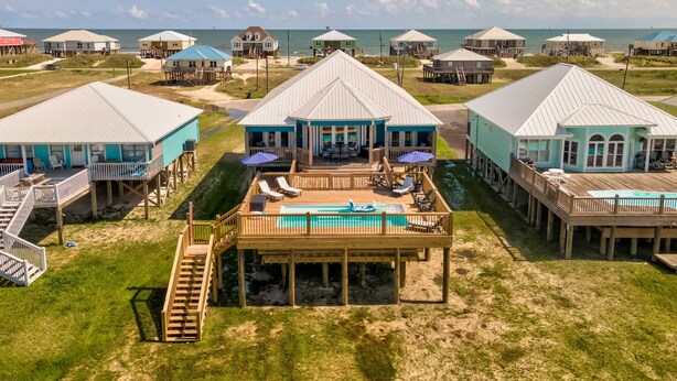 Ein direkt am Strand gelegenes Anwesen mit mehreren Holzhäusern, einem Schwimmbad und einer Sonnenterrasse.