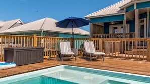 Ein Poolbereich mit Liegestühlen, Sonnenschirm und Whirlpool.