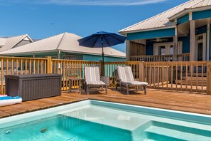 A pool area with lounge chairs, an umbrella, and a hot tub. - Bayfront home with beach access & breathtaking water views - dog-friendly (Dauphin Island)