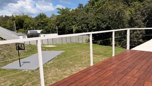 A wooden deck with a basketball hoop and a white fence. - Tierra Serena - Private Nature Retreat (Rincón)