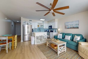 A modern kitchen with white cabinets, a stainless steel refrigerator, and a ceiling fan. - 6th-floor remodeled condo w/ Gulf views, beach access, pools, tennis, & BBQ area (Orange Beach)