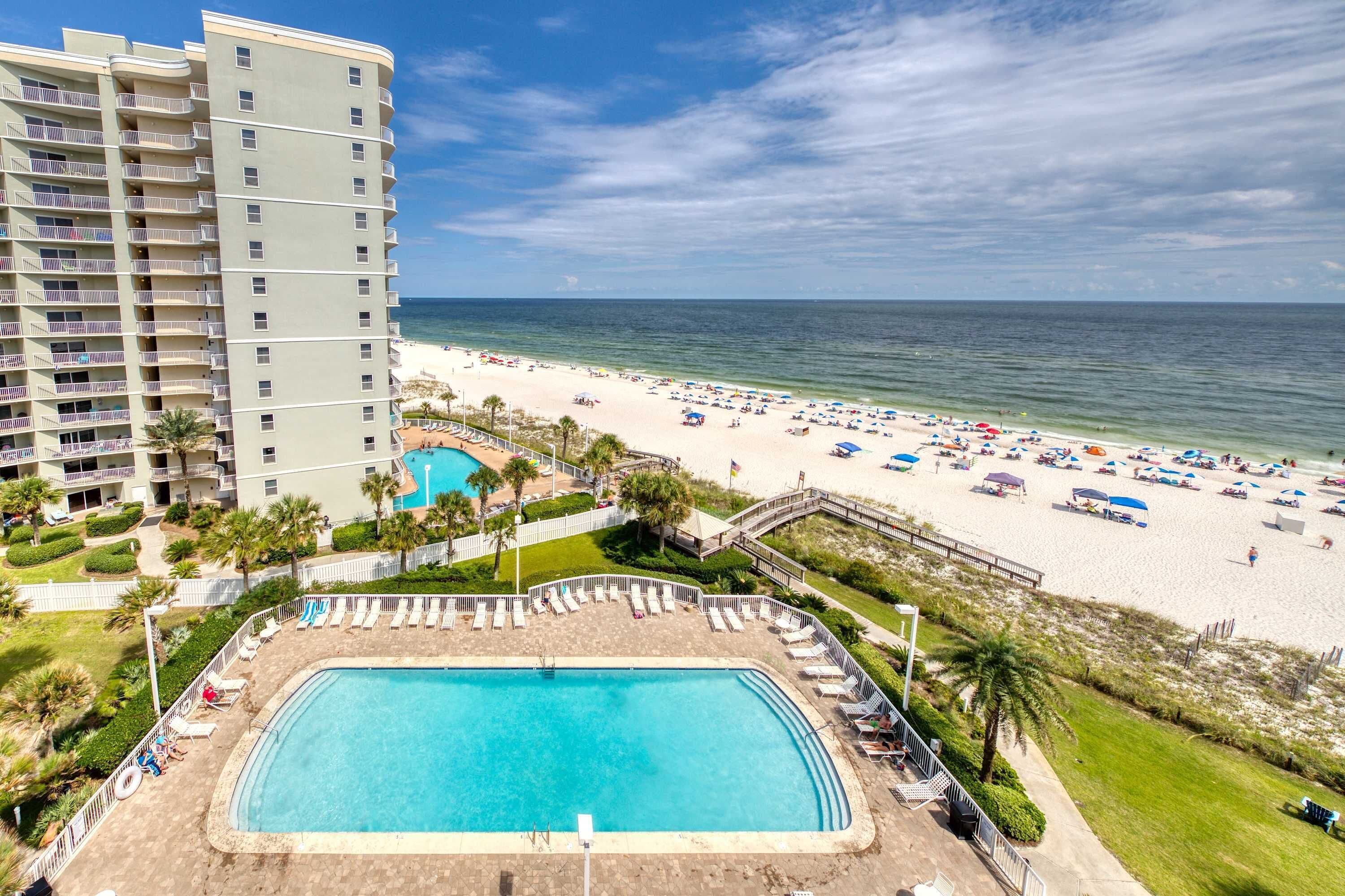 Um hotel com piscina, praia e vista para o oceano.