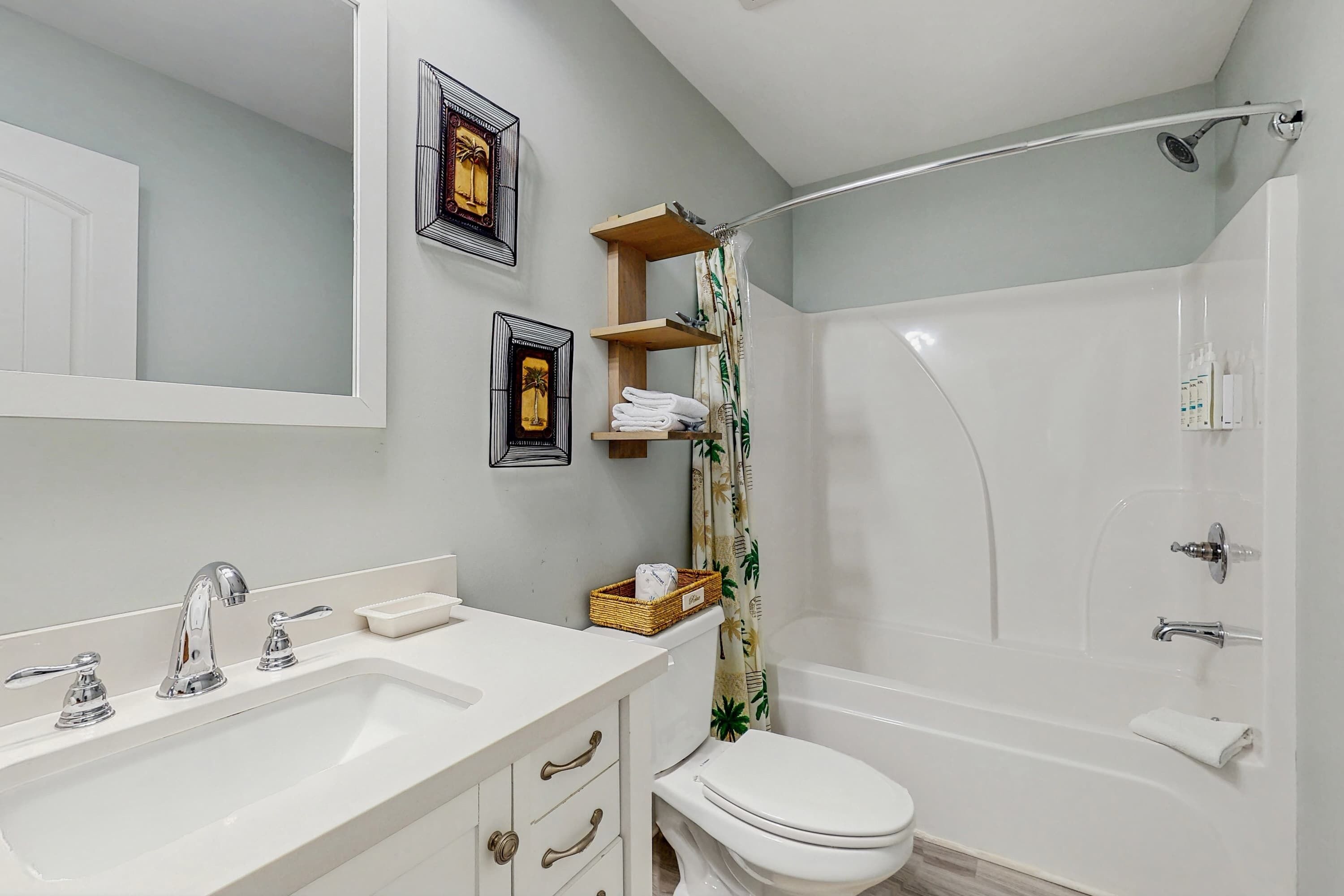 A bathroom with a sink, toilet, and shower.