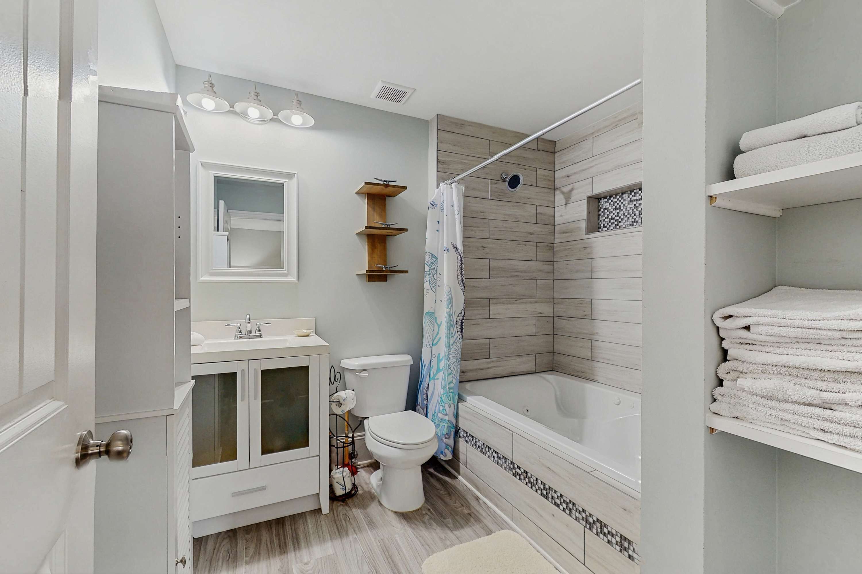 A bathroom with a toilet, sink, vanity, shower, and bathtub.