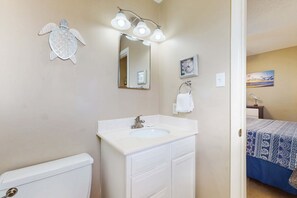 A bathroom with a white sink, a mirror, and a towel rack. - Family-friendly, beachfront getaway with a stainless kitchen & shared pool (Dauphin Island)