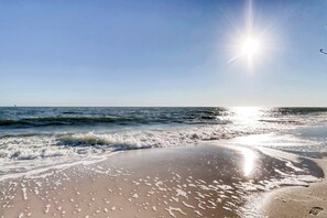 A beach with waves, a clear sky, and the sun shining. - Beach Front house with breathtaking views, free WiFi, full kitchen (Dauphin Island)