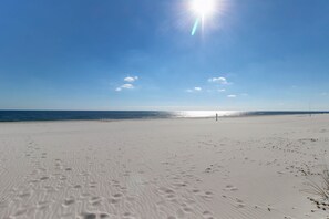 A beach with footprints, a clear sky, and the ocean in the background. - Bright beachfront condo with 2 Gulf-side pools, tennis courts & fitness room (Orange Beach)