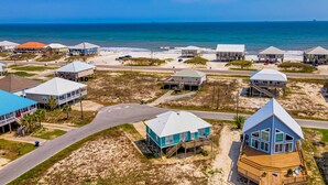 A coastal area with beach houses, a road, and the ocean. - Newly remodeled bay view home with high-speed WiFi, central AC, and gas grill (Dauphin Island)